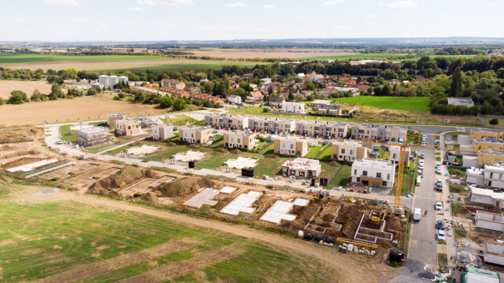 Letecký pohled na developerský projekt rodinných domů v Praze a okolní stavební pozemky