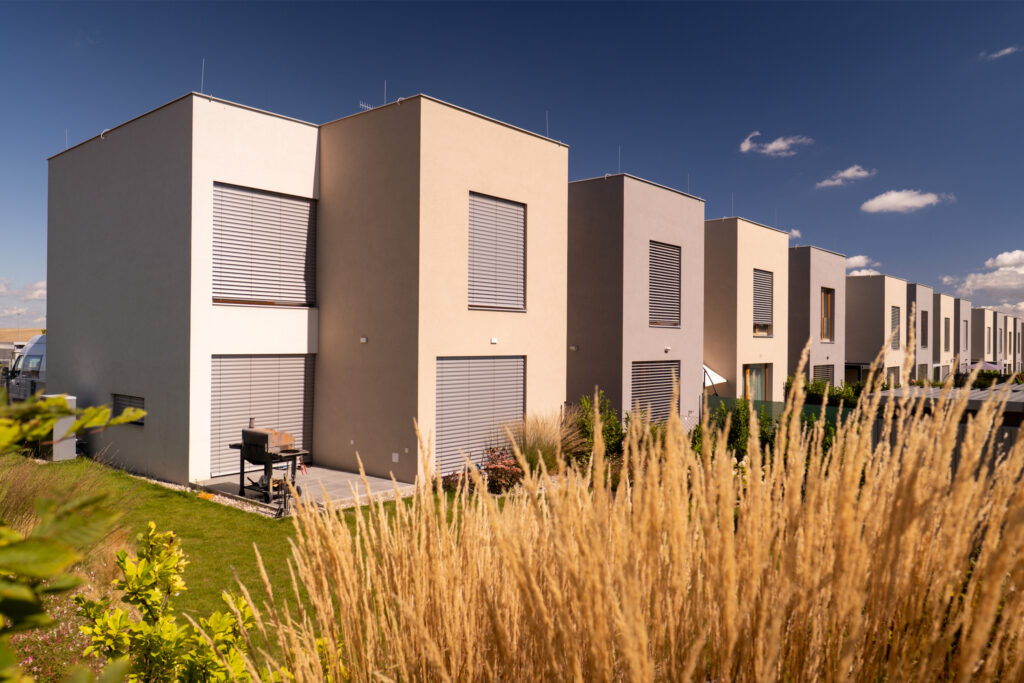 Řadové novostavby rodinných domů v moderním developerském projektu s předzahrádkami a zelení