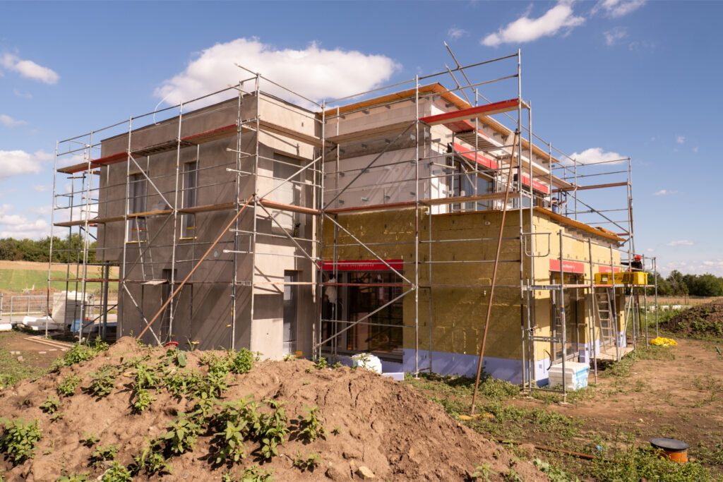 Rodinný dům ve výstavbě obklopený lešením, pohled na kvalitu hrubé stavby a zateplení.