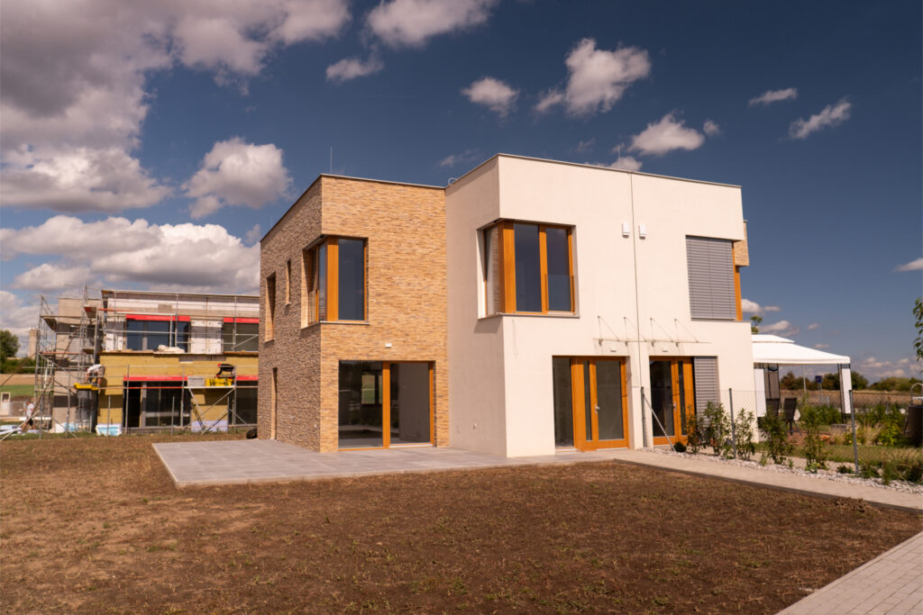 Moderní novostavba rodinného domu s velkými okny v rezidenční lokalitě Prahy, vhodná jako investice do nemovitosti a pronájem novostavby.